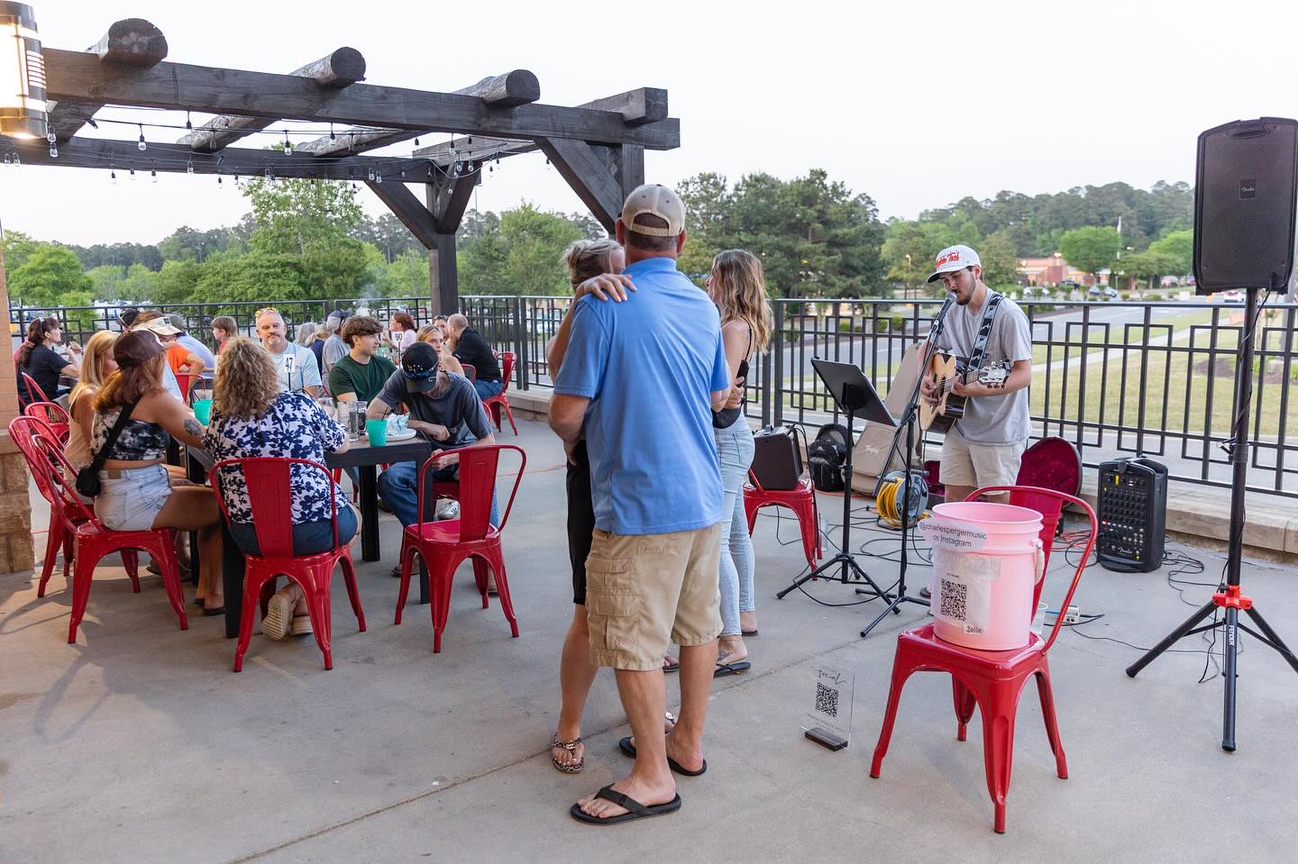 Outdoor patio at Duke’s Aloha Eats with guests enjoying live music by a Charlie Perger